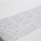 Metallic silver glitter mesh table runner on a white table.