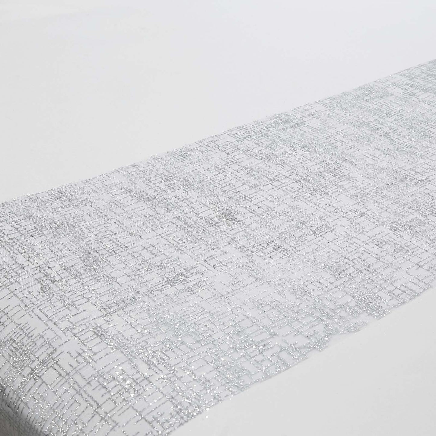 Metallic silver glitter mesh table runner on a white table.