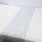 Metallic silver glitter mesh table runner on a white table.