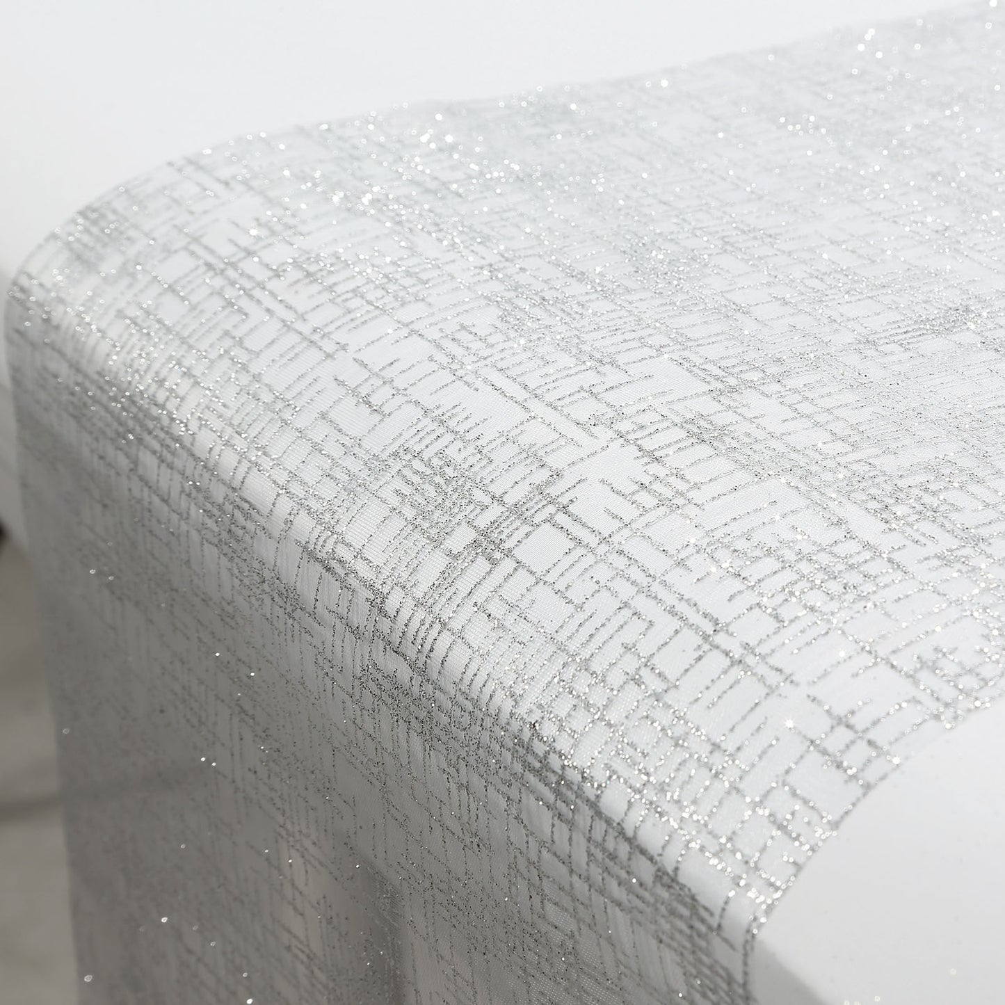 Metallic silver glitter mesh polyester disposable table runner on a white table.