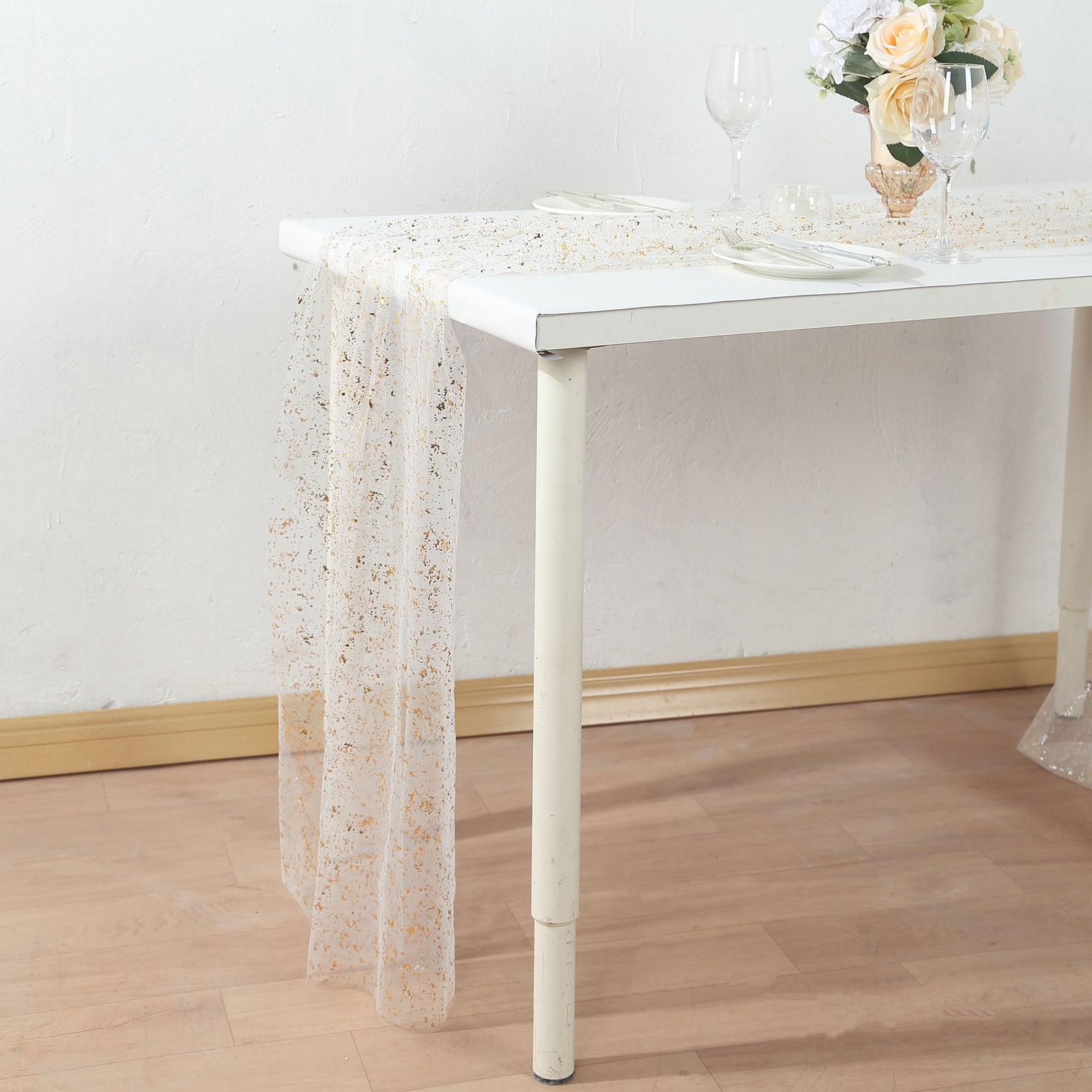 Metallic gold glitter sheer chiffon table runner on a white table.