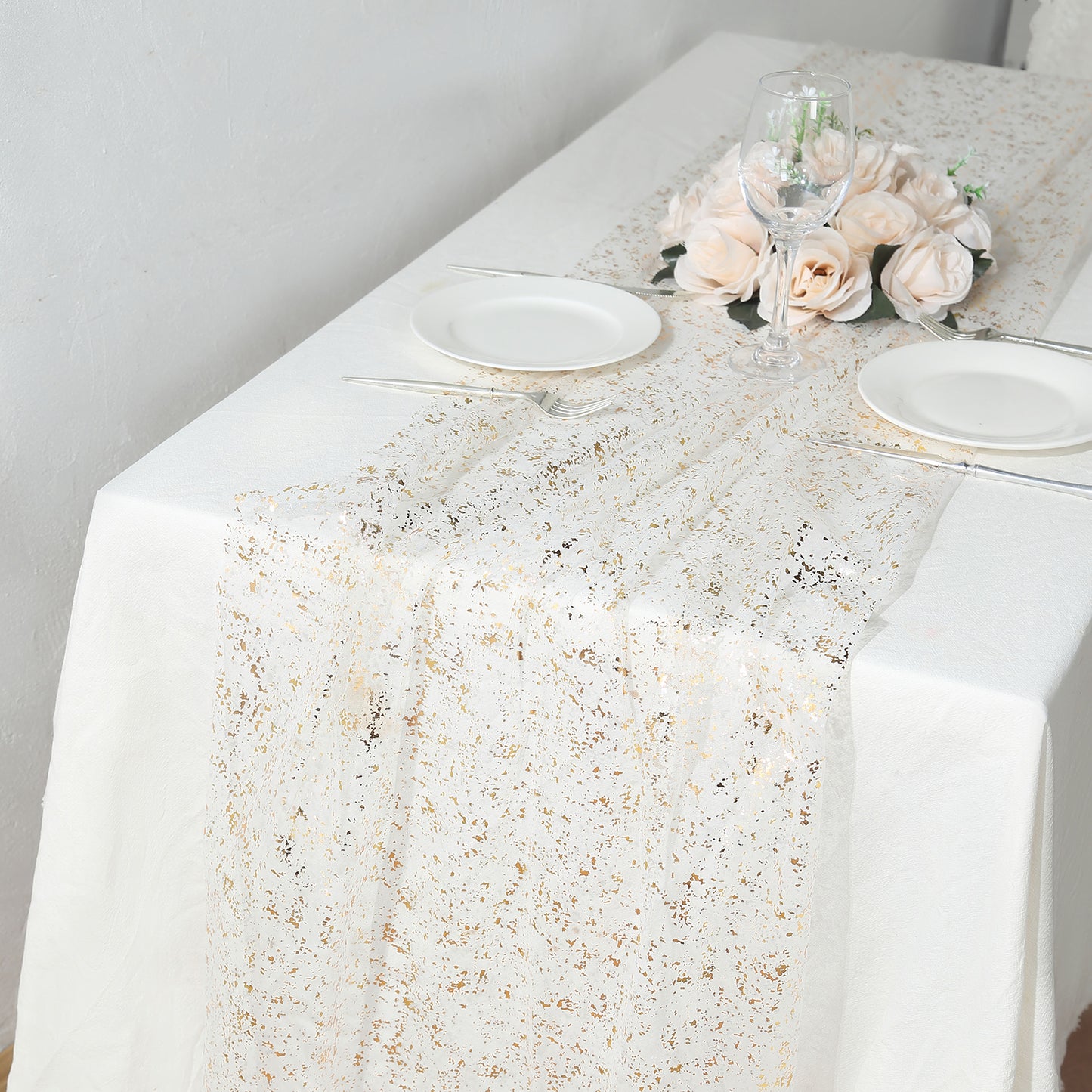 Metallic gold glitter sheer chiffon table runner on a white table.