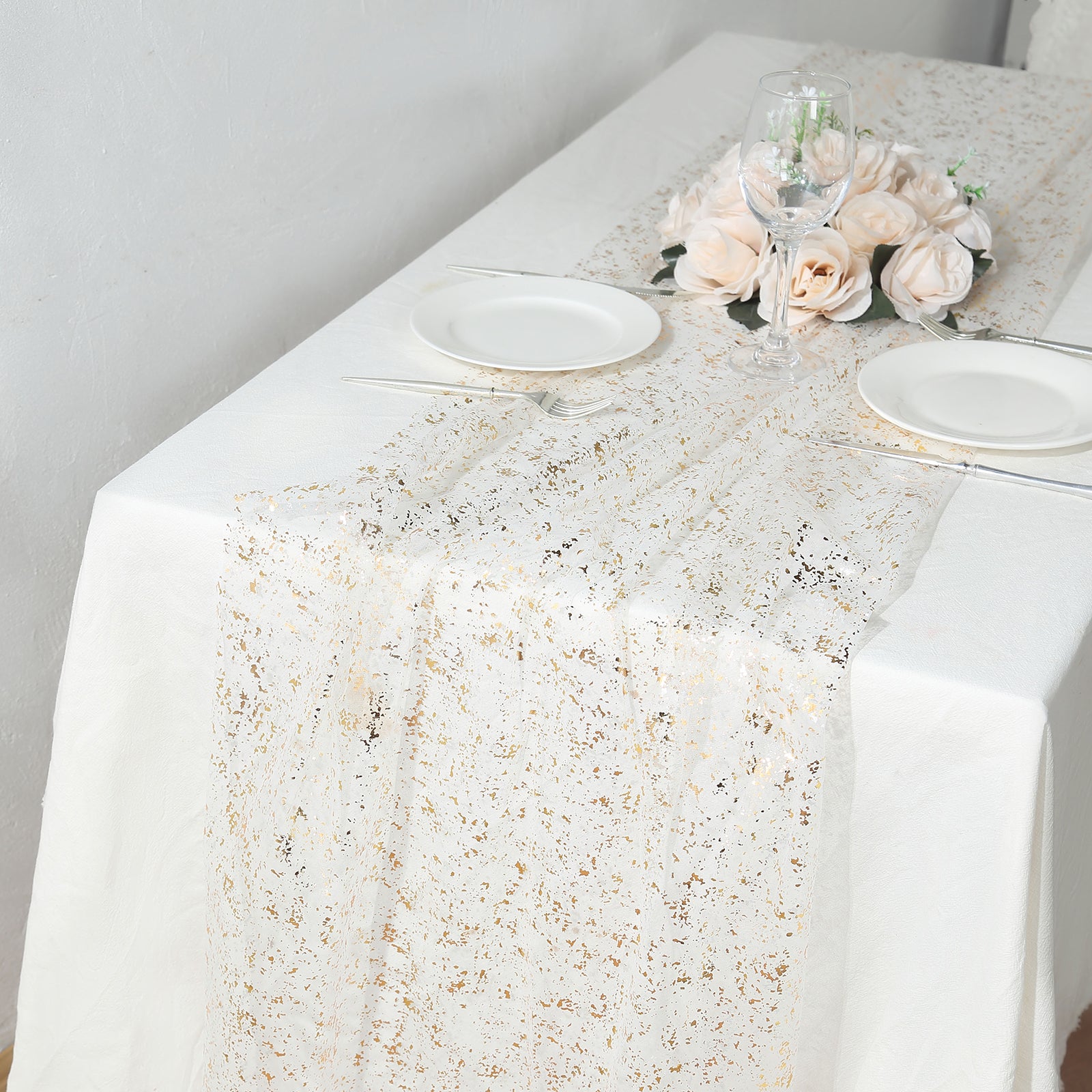 Metallic gold glitter sheer chiffon table runner on a white table.