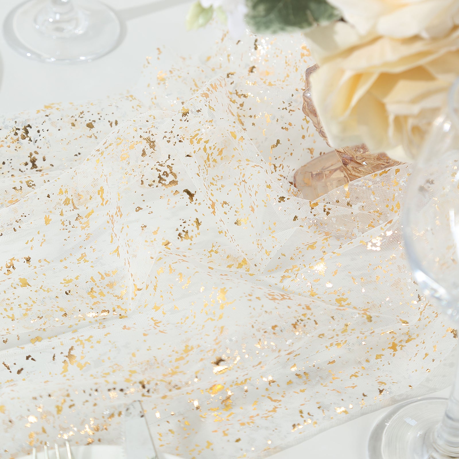 Metallic gold glitter sheer chiffon table runner on a wedding table.