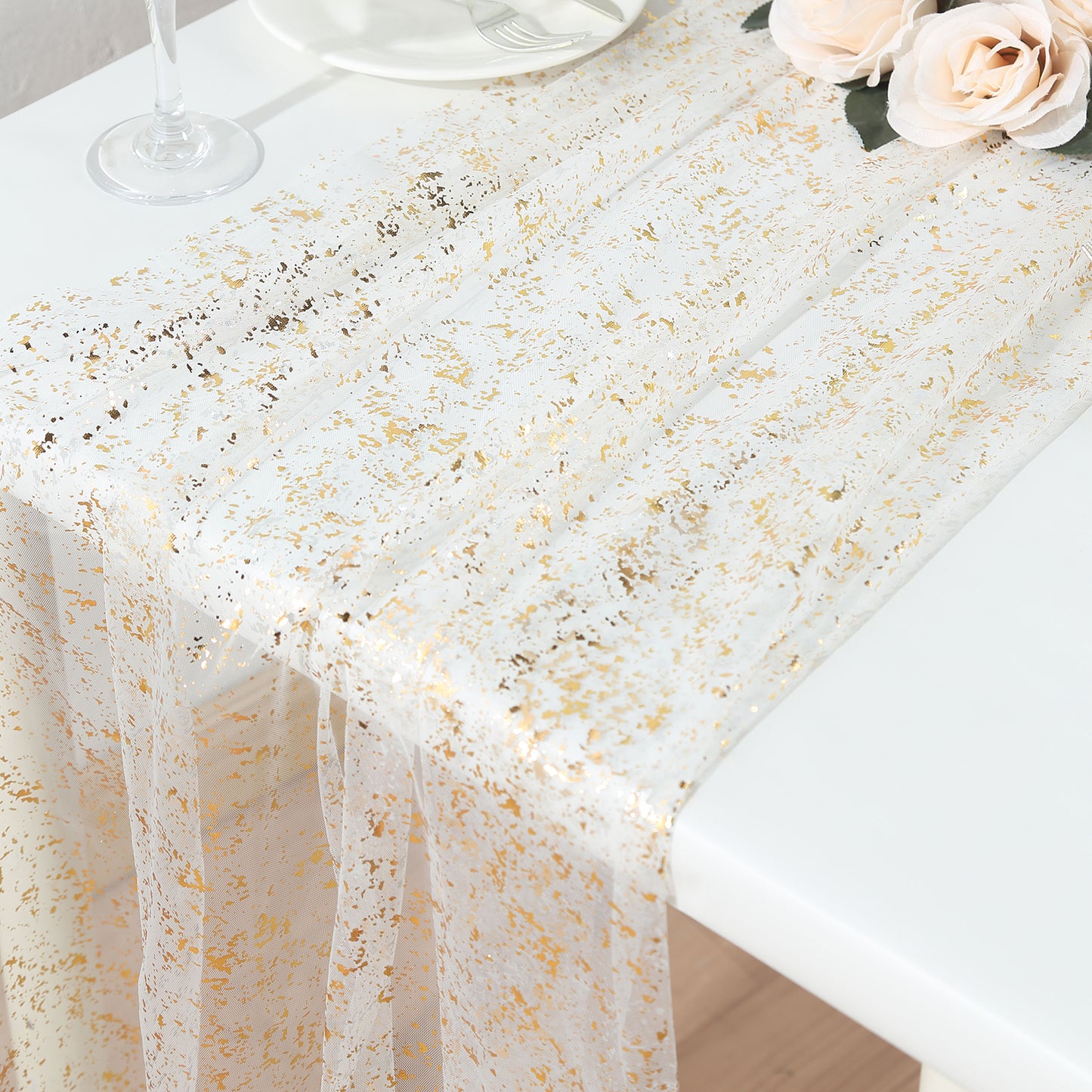 Metallic gold glitter sheer chiffon table runner on a white table.