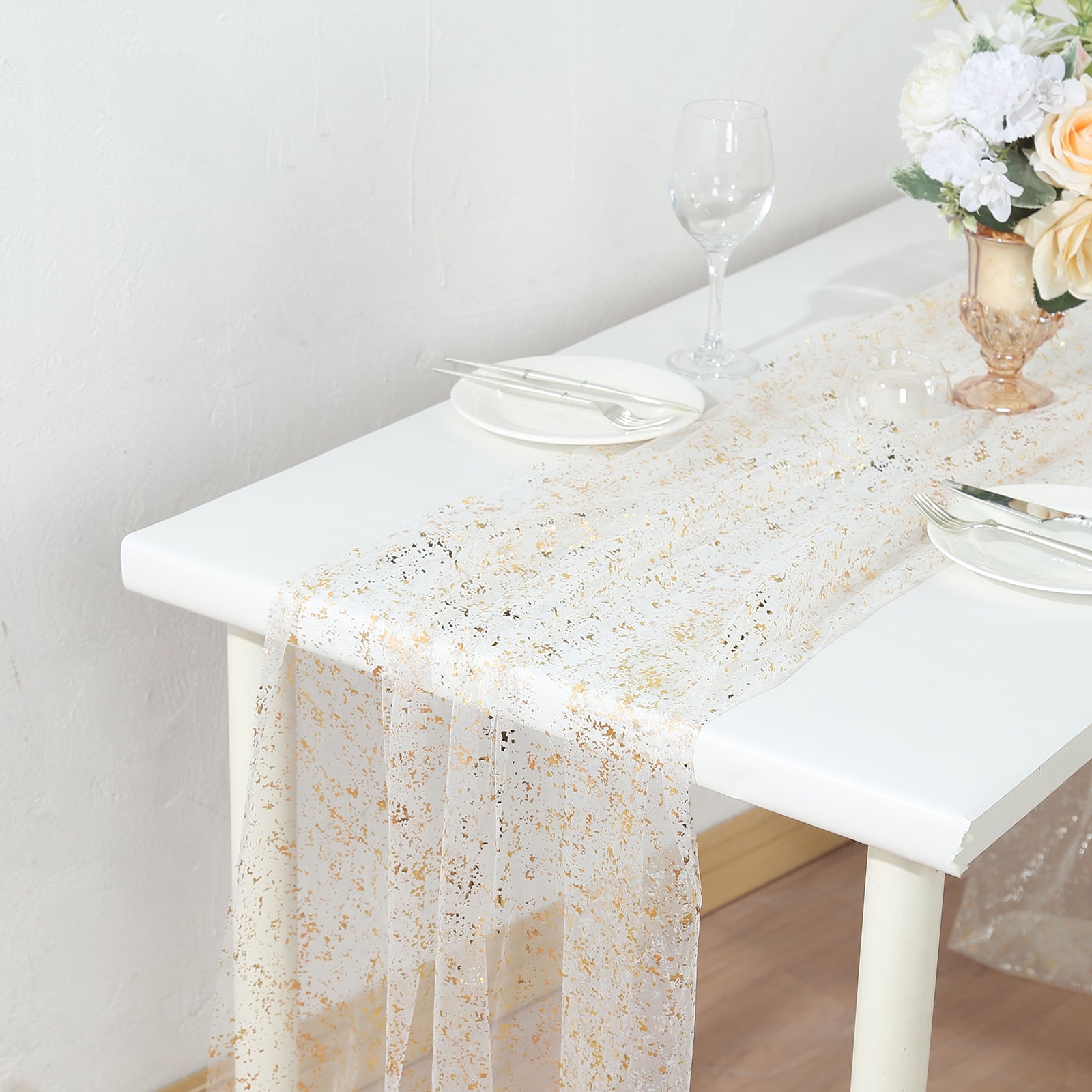 Metallic gold glitter sheer chiffon table runner on a white table.