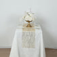 Gold mesh organza table runner with gold foil wave pattern on a white table.