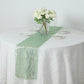 Emerald green mesh organza table runner with gold foil wave pattern on a round table.