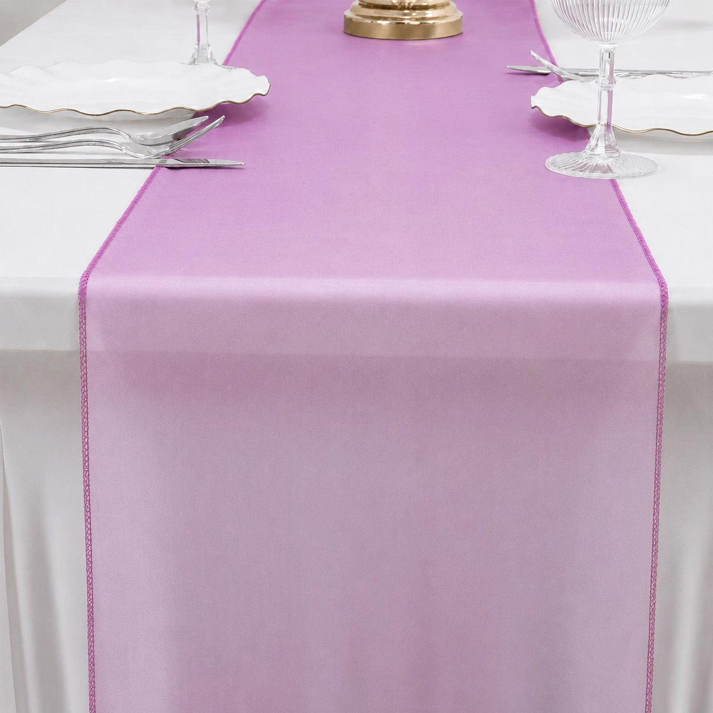 Fuchsia sheer organza table runner on a dining table.