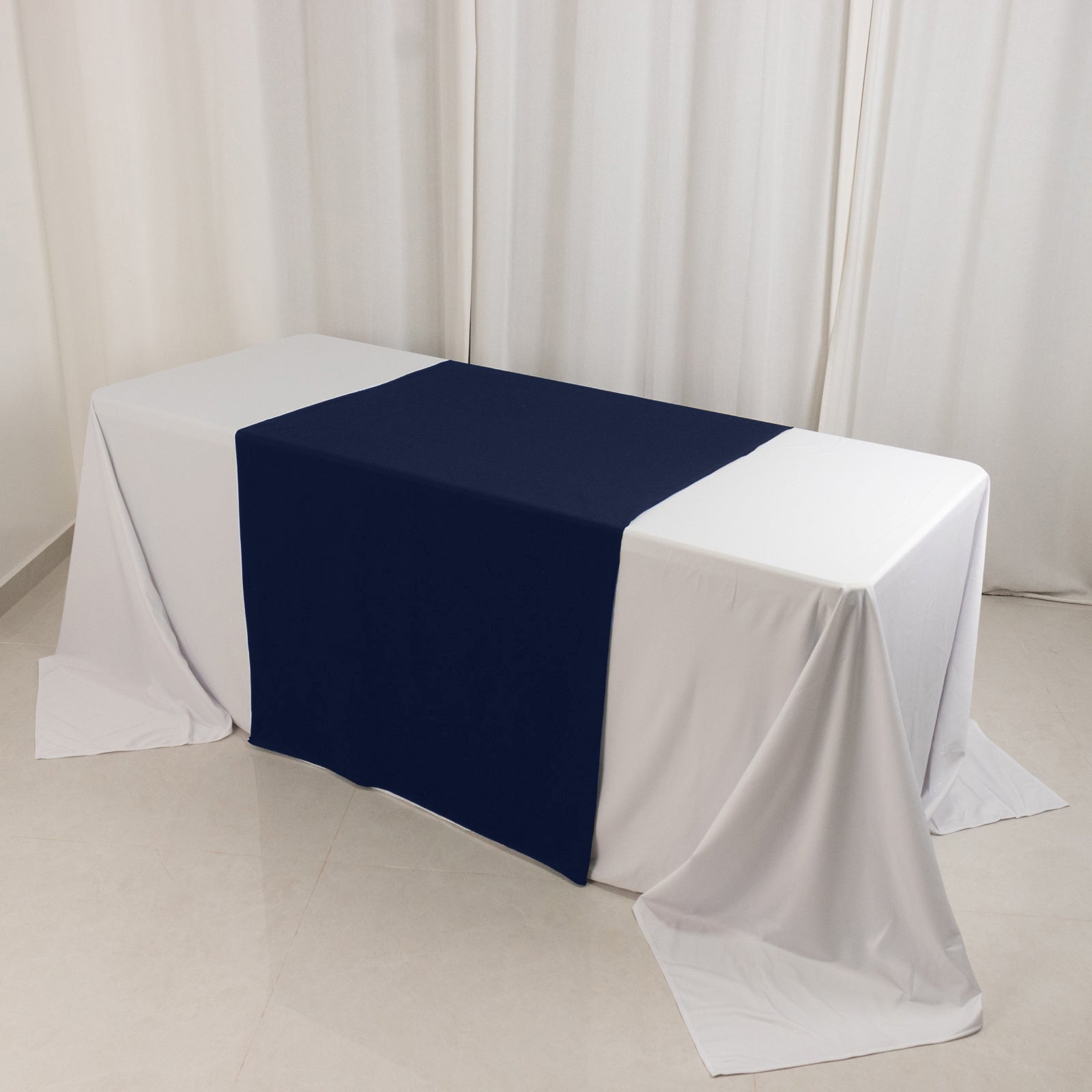 Navy blue table runner on a white table in a trade show setting.
