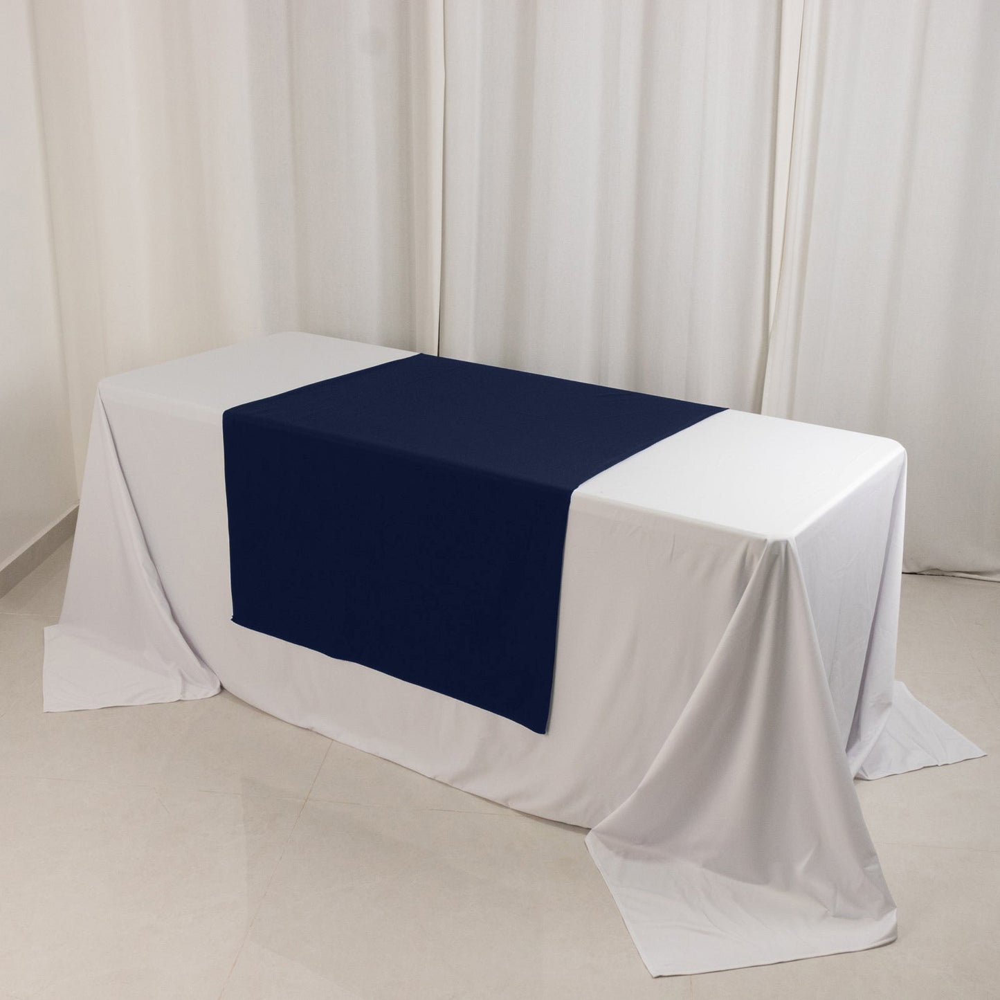 Navy blue table runner on a white table at a trade show.