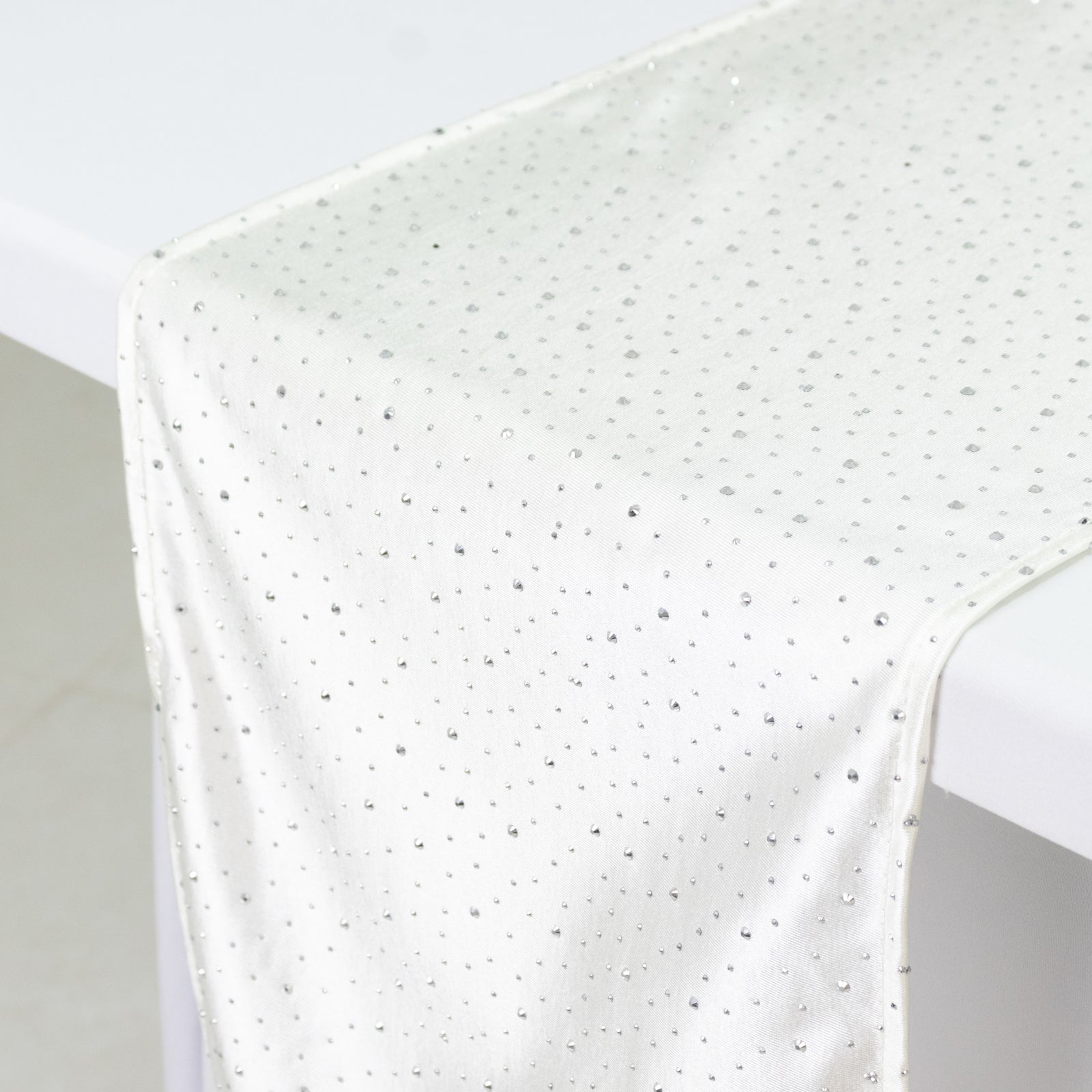Pearl white scuba table runner with rhinestone accents on a table.