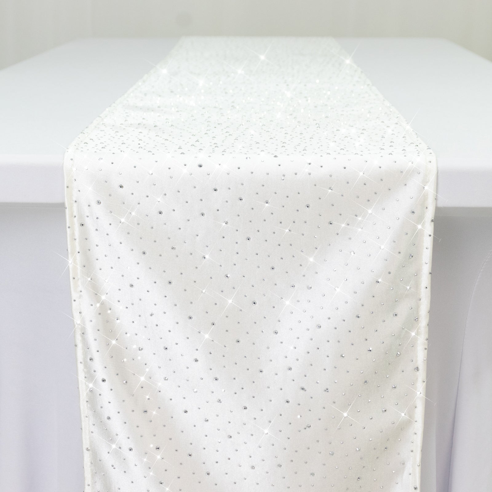 Pearl white scuba table runner with rhinestone accents on a table.
