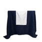 White scuba table runner with rhinestone accents on a dark blue table.