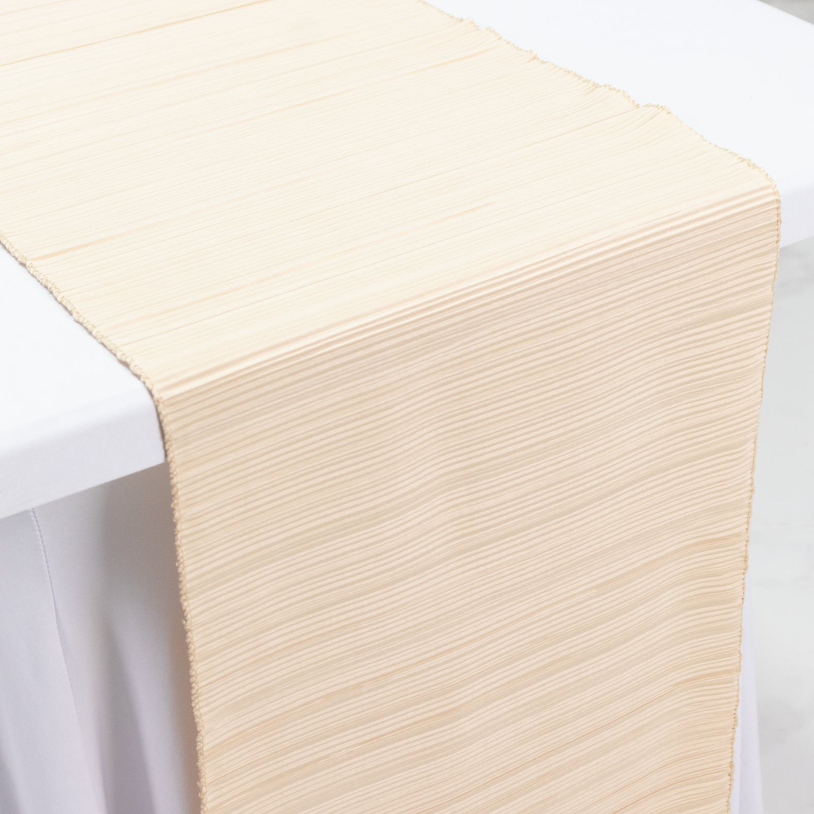 Beige accordion pleated table runner, wrinkle free and stain resistant.