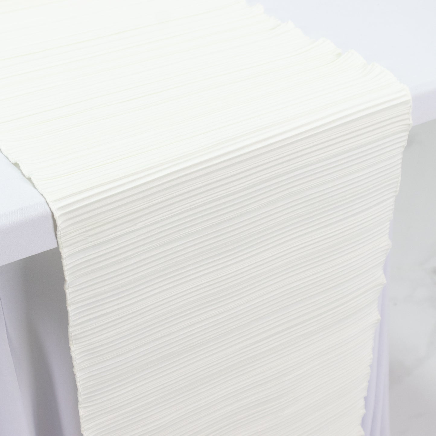 Ivory accordion pleated scuba table runner, 12" x 108", wrinkle-free and stain-resistant.