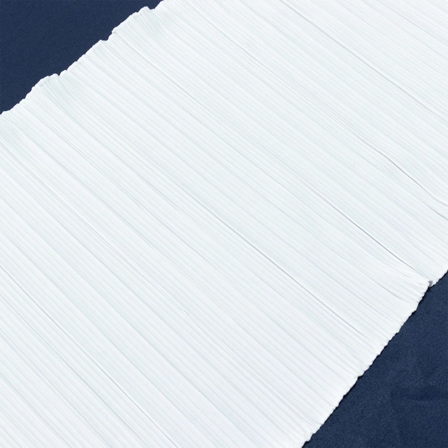 White accordion pleated scuba table runner on a dark background. #whtbkgd