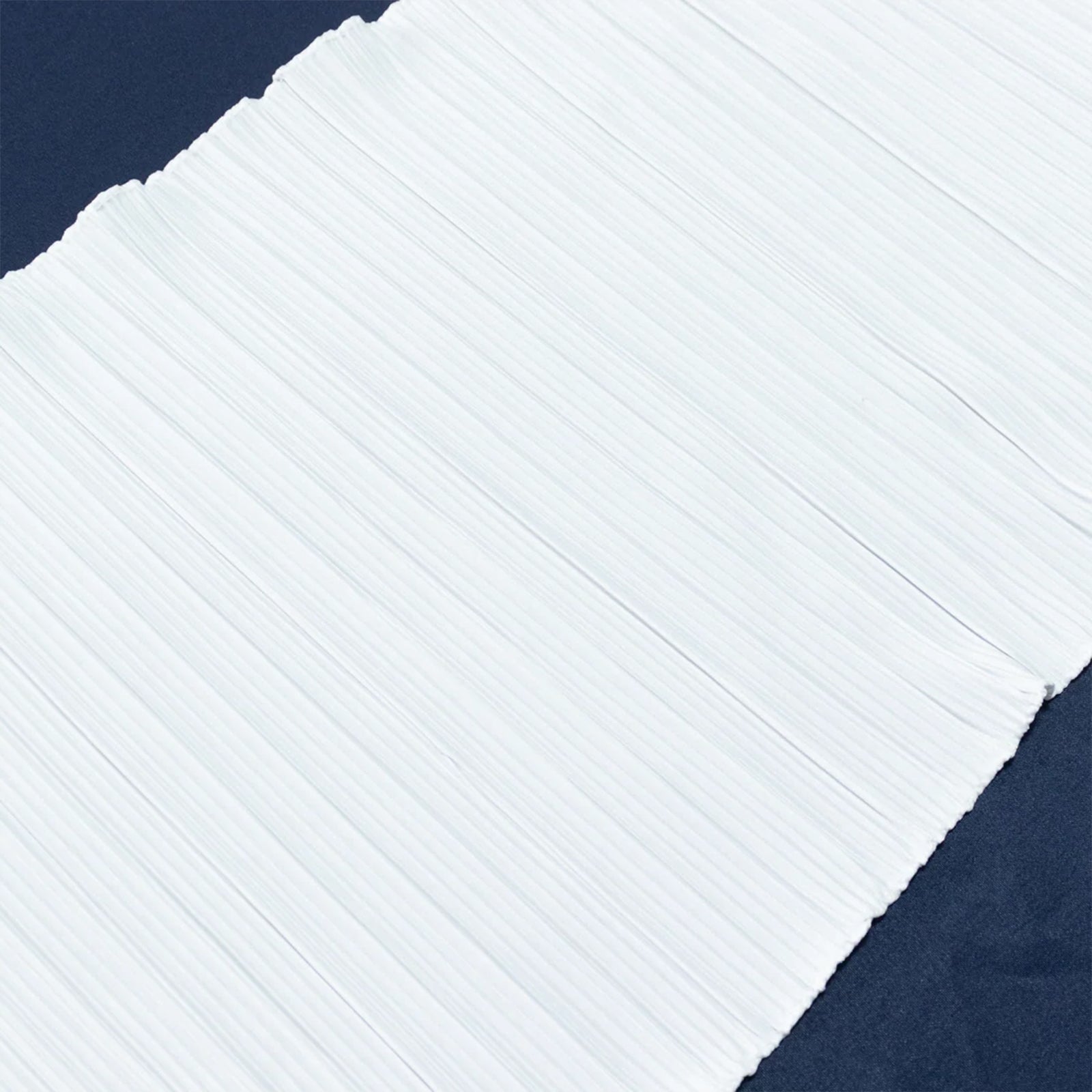 White accordion pleated scuba table runner on a dark background. #whtbkgd