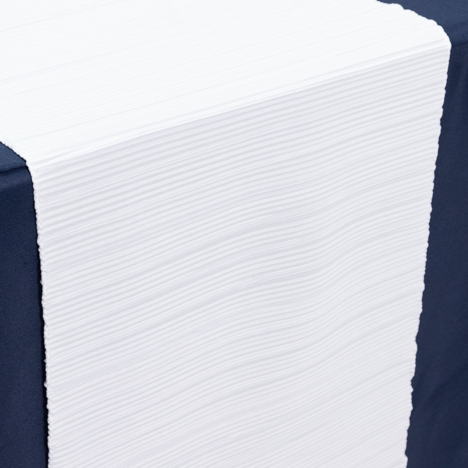 White accordion pleated table runner on a dark table.