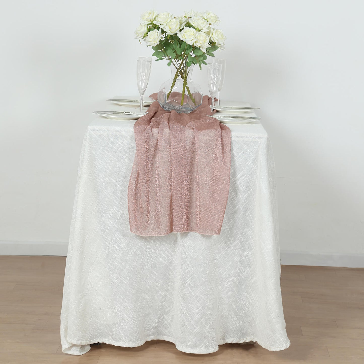 Rose gold sparkling glitter gauze table runner on a white table.