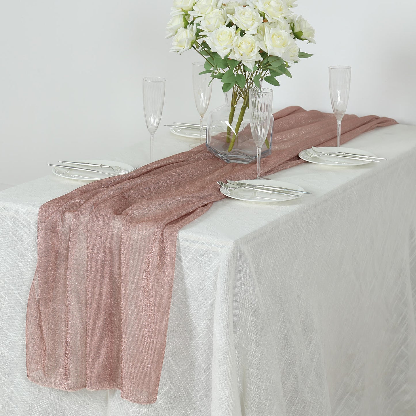 Rose gold sparkling glitter sheer table runner on a white table.