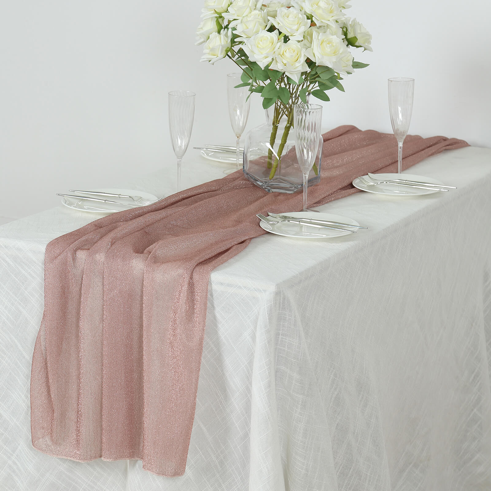 Rose gold sparkling glitter sheer table runner on a white table.