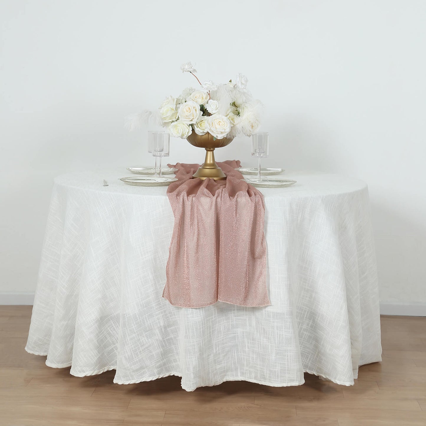 Rose gold sparkling glitter table runner on a white table.