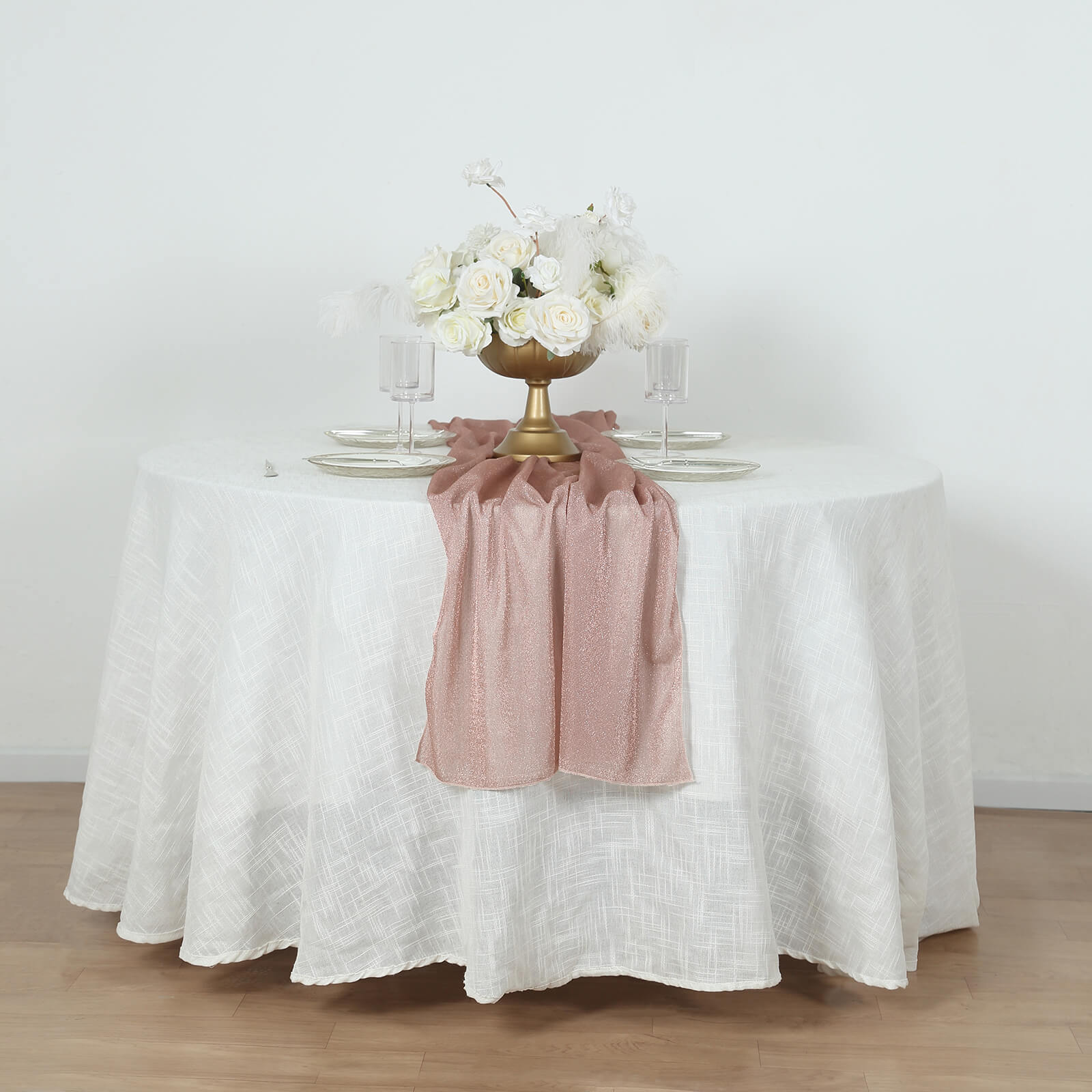 Rose gold sparkling glitter table runner on a white table.