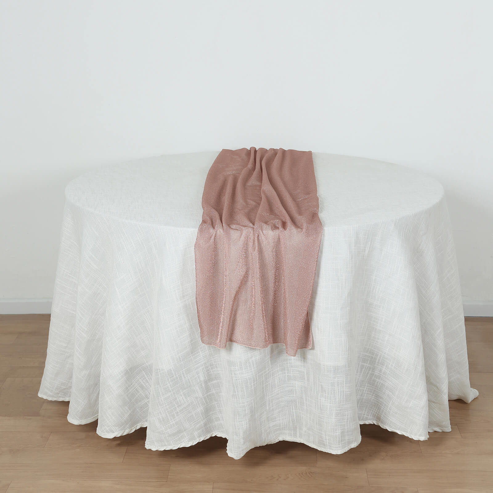 Rose gold sparkling glitter gauze table runner on a white table.