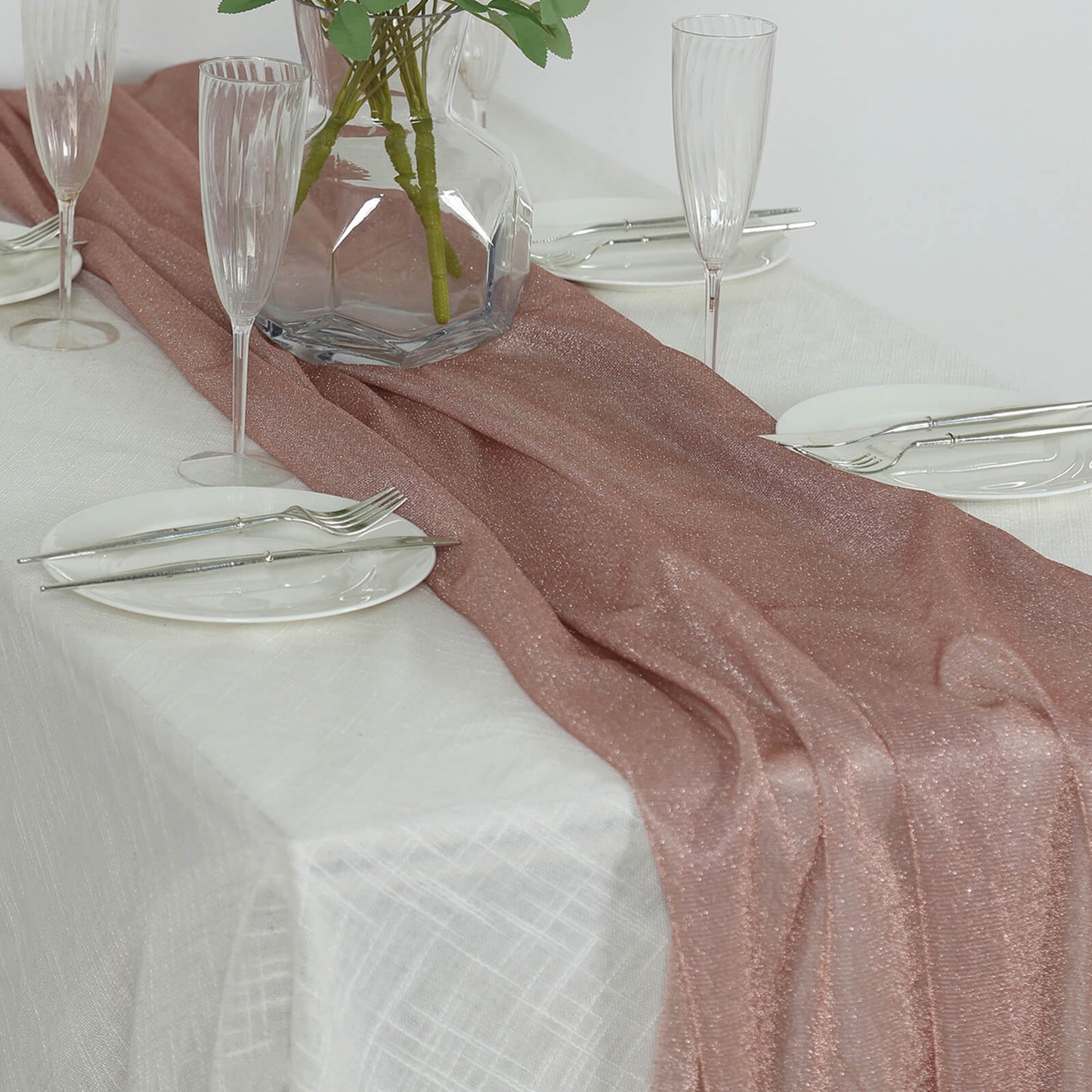 Rose gold sparkling glitter table runner on a white table.