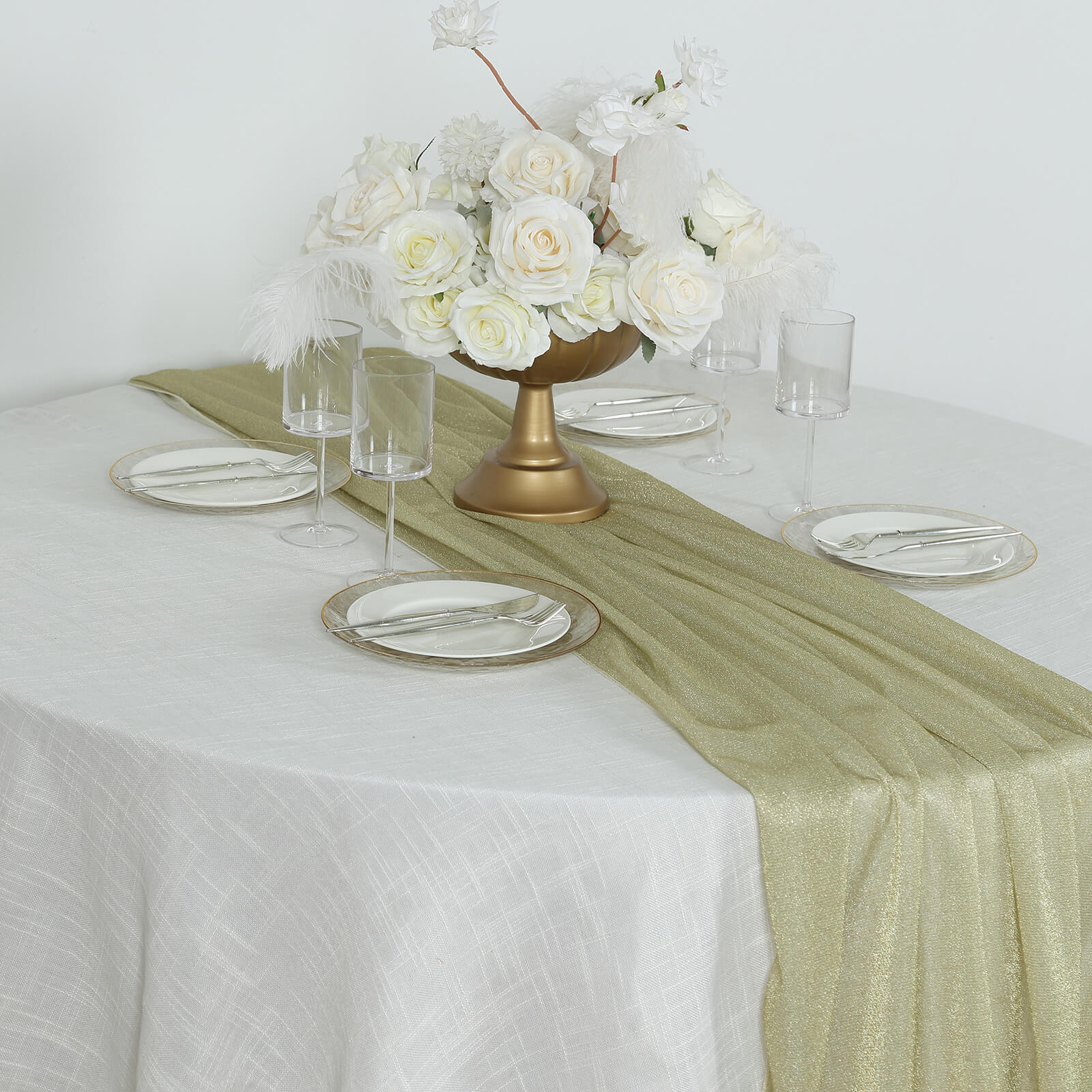Champagne sparkling glitter gauze table runner on a white table with flowers.