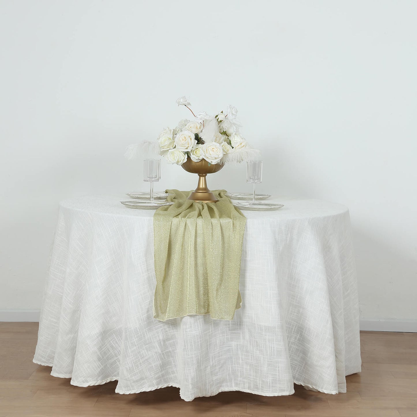 Champagne sparkling glitter gauze table runner on a white table with floral centerpiece.