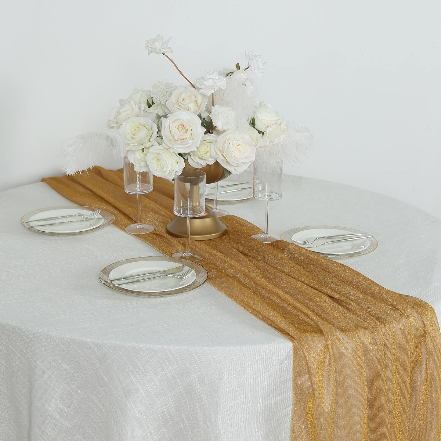 Gold sparkling glitter gauze table runner on a round table setting.