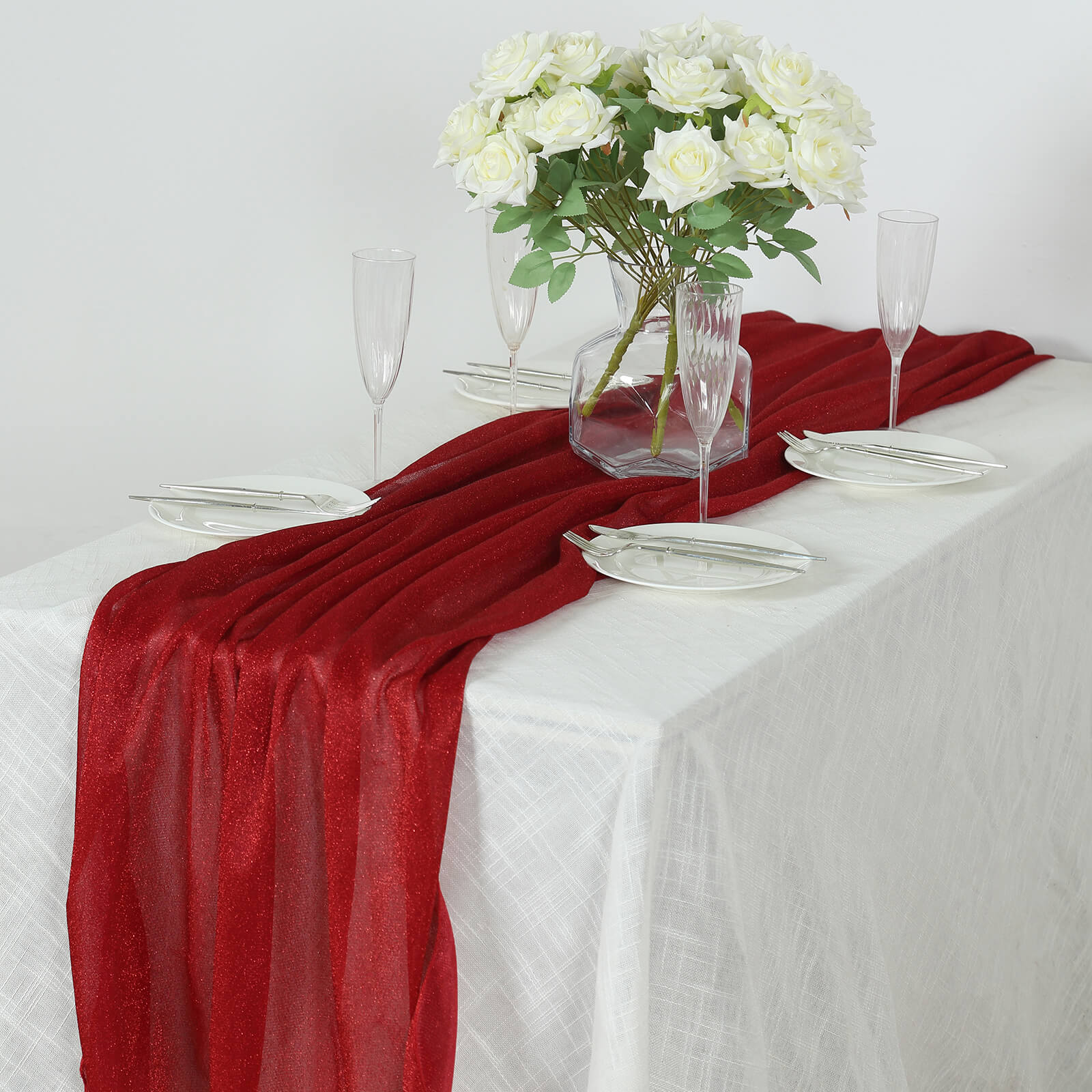 Red sparkling glitter gauze table runner on a dining table.