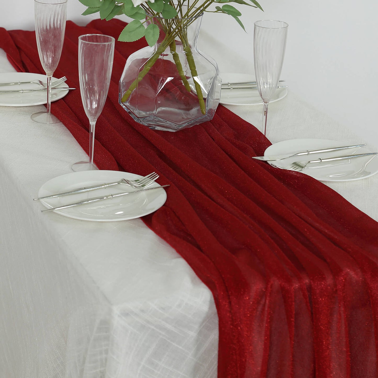 Red sparkling glitter gauze table runner on a dining table.