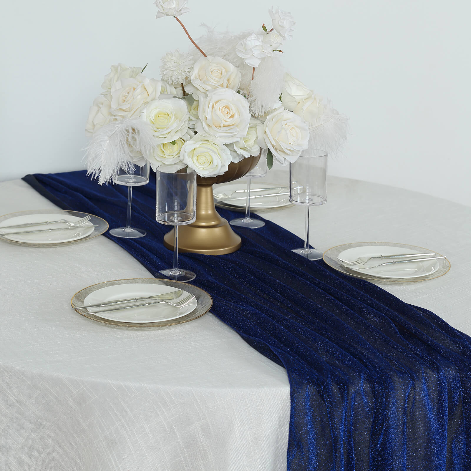 Royal blue sparkling glitter table runner on a dining table with floral arrangement.