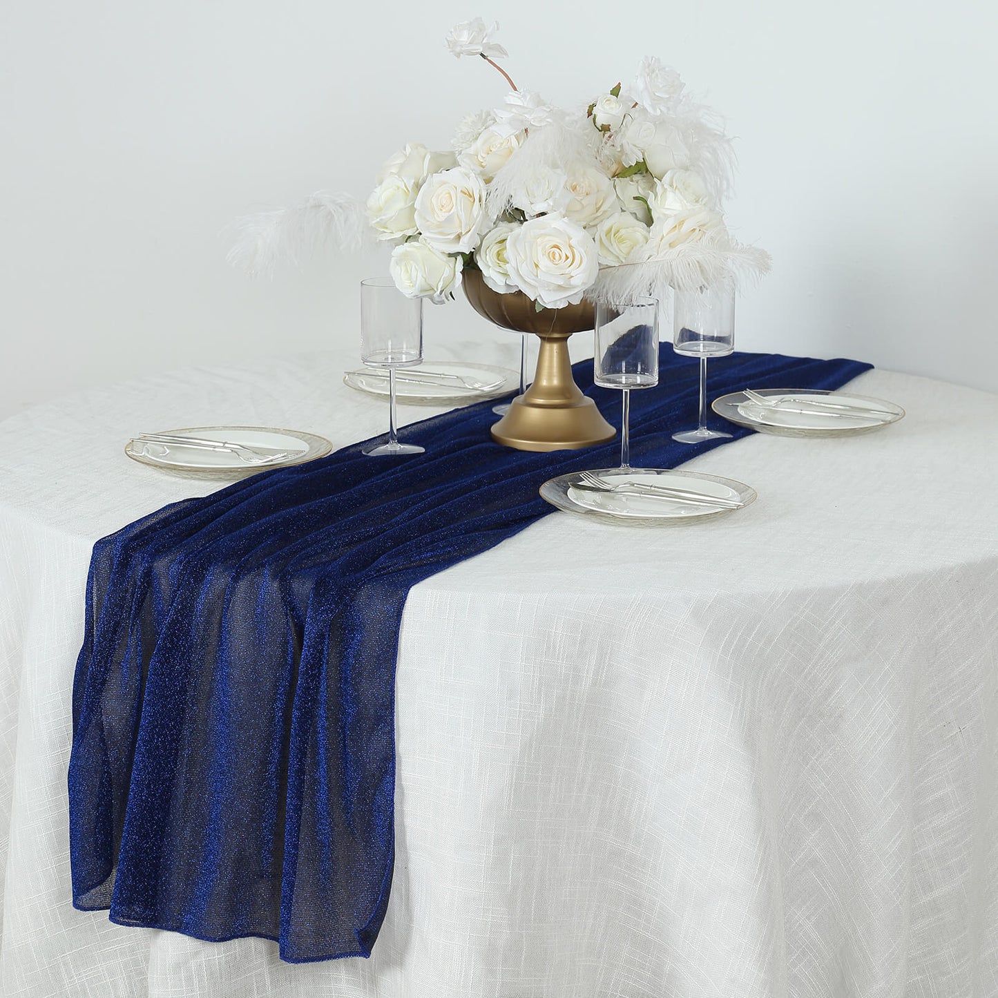 Royal blue sparkling glitter table runner on a dining table with floral centerpiece.