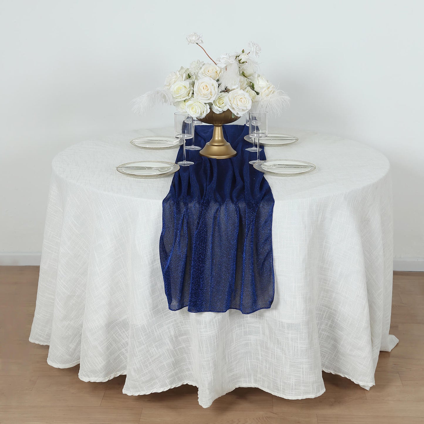 Royal blue sparkling glitter gauze table runner on a white table.