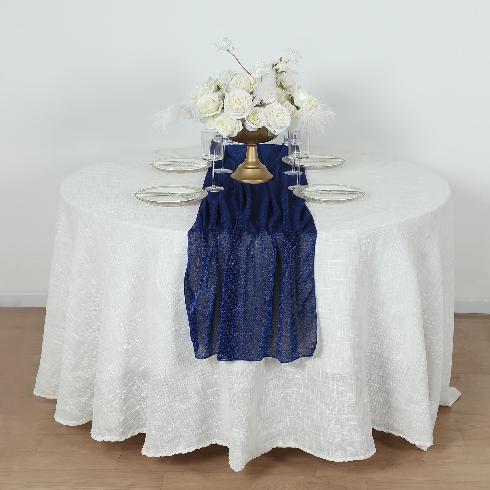 Royal blue sparkling glitter gauze table runner on a white table.