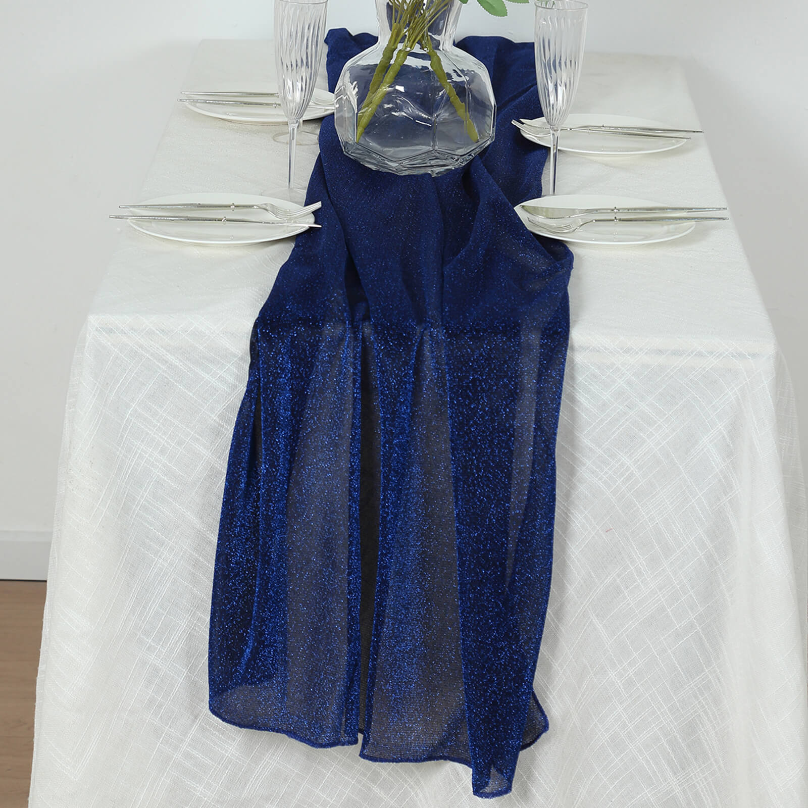 Royal blue sparkling glitter table runner on a white table setting.