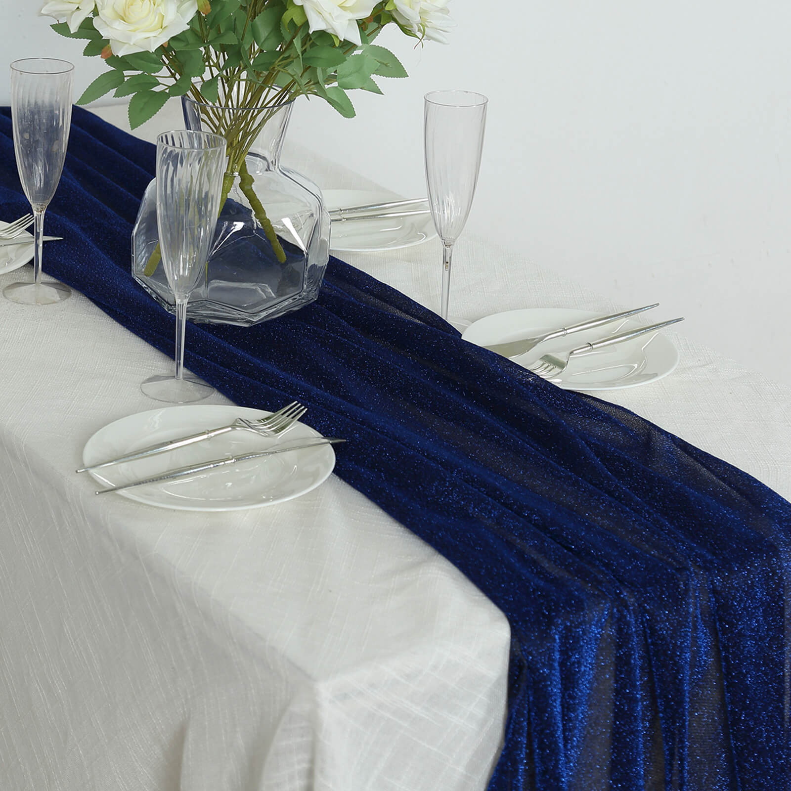 Royal blue sparkling glitter table runner on a white table setting.