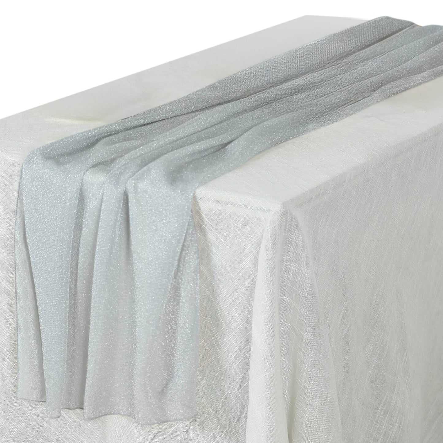 Silver sparkling glitter gauze table runner on a white table.