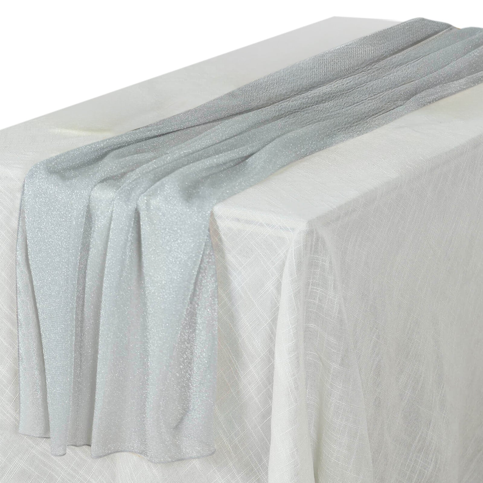 Silver sparkling glitter gauze table runner on a white table.