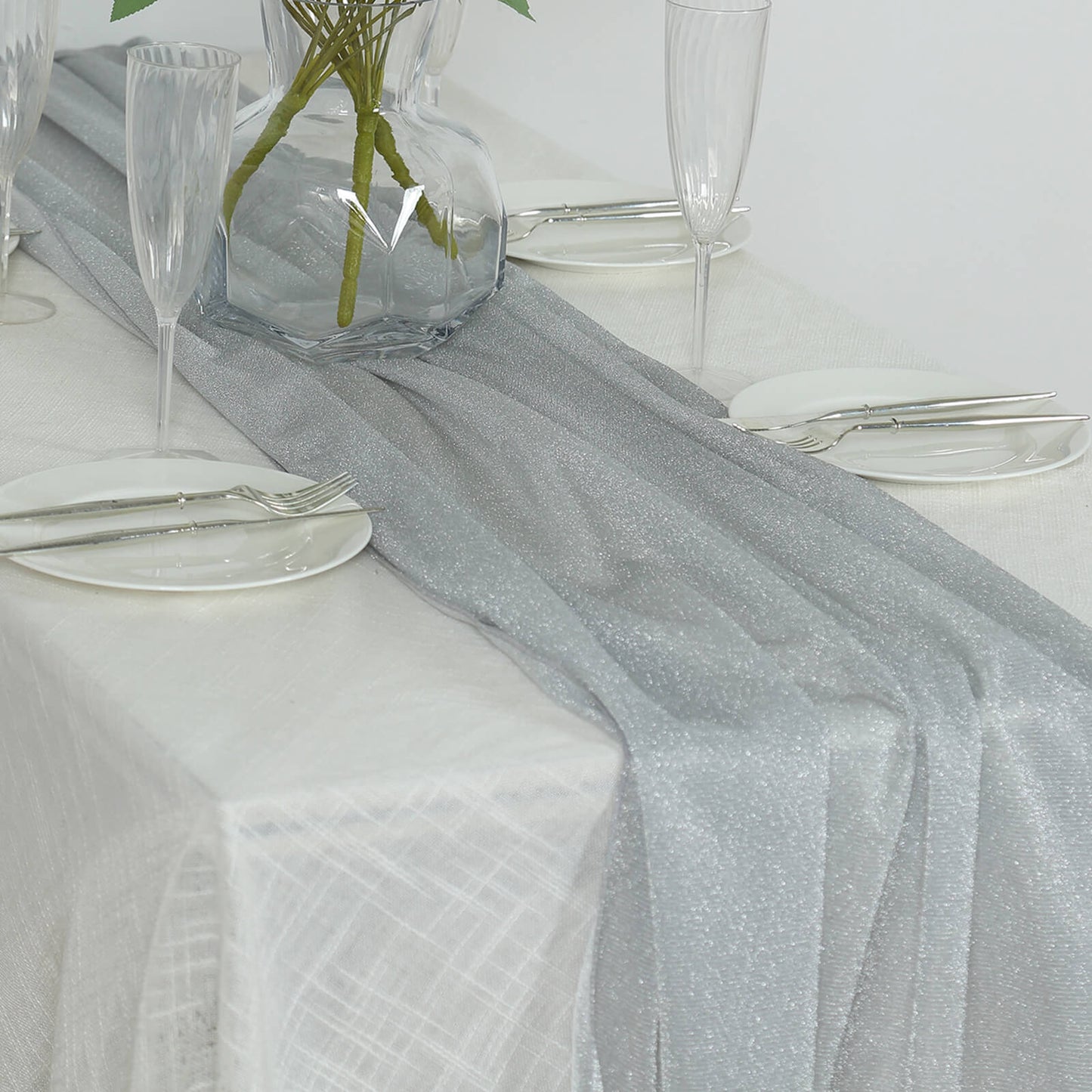 Silver sparkling glitter table runner on a white table setting.