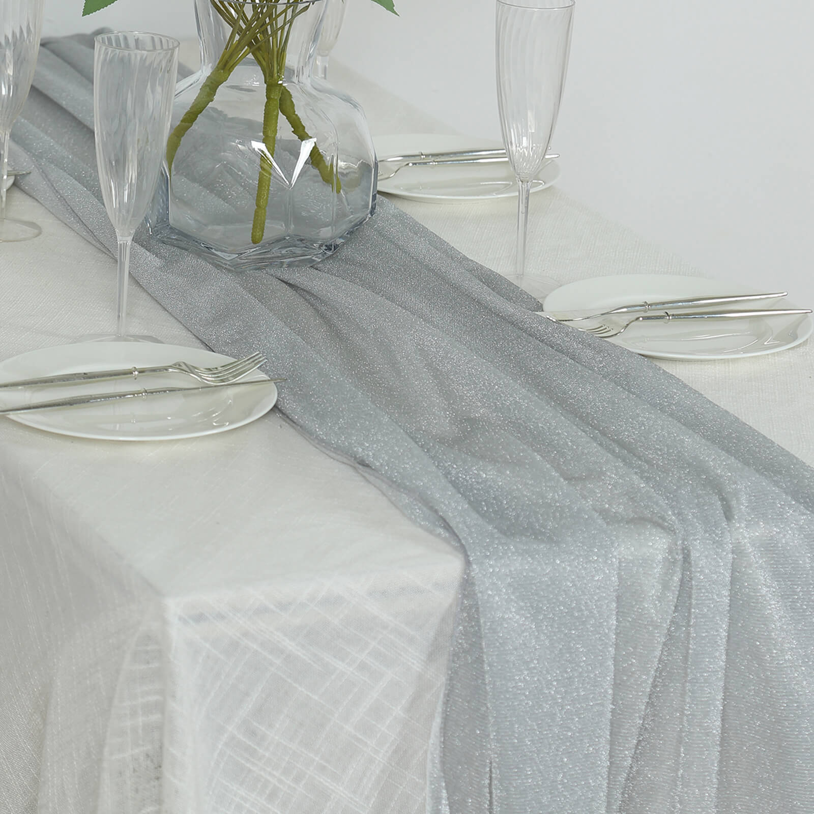 Silver sparkling glitter table runner on a white table setting.