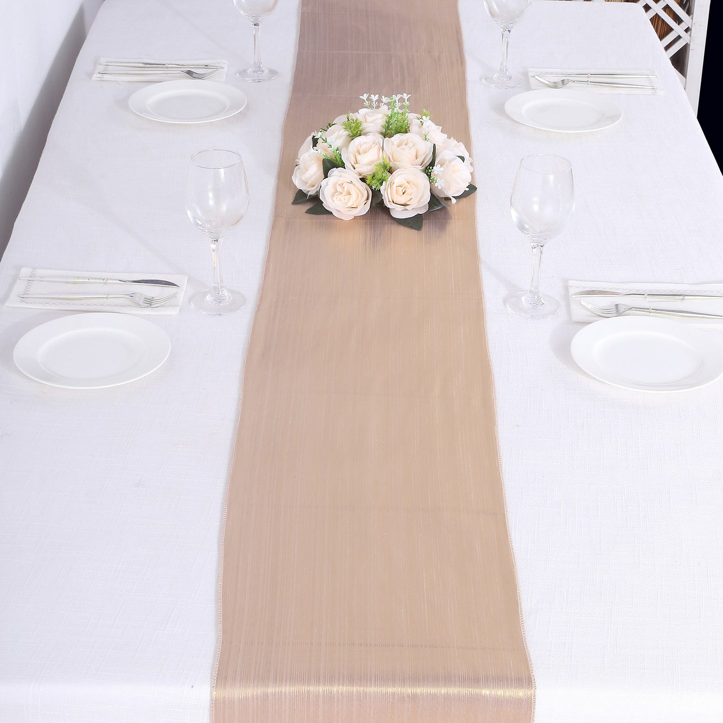 Blush shimmer sequin table runner on a white table with floral centerpiece.