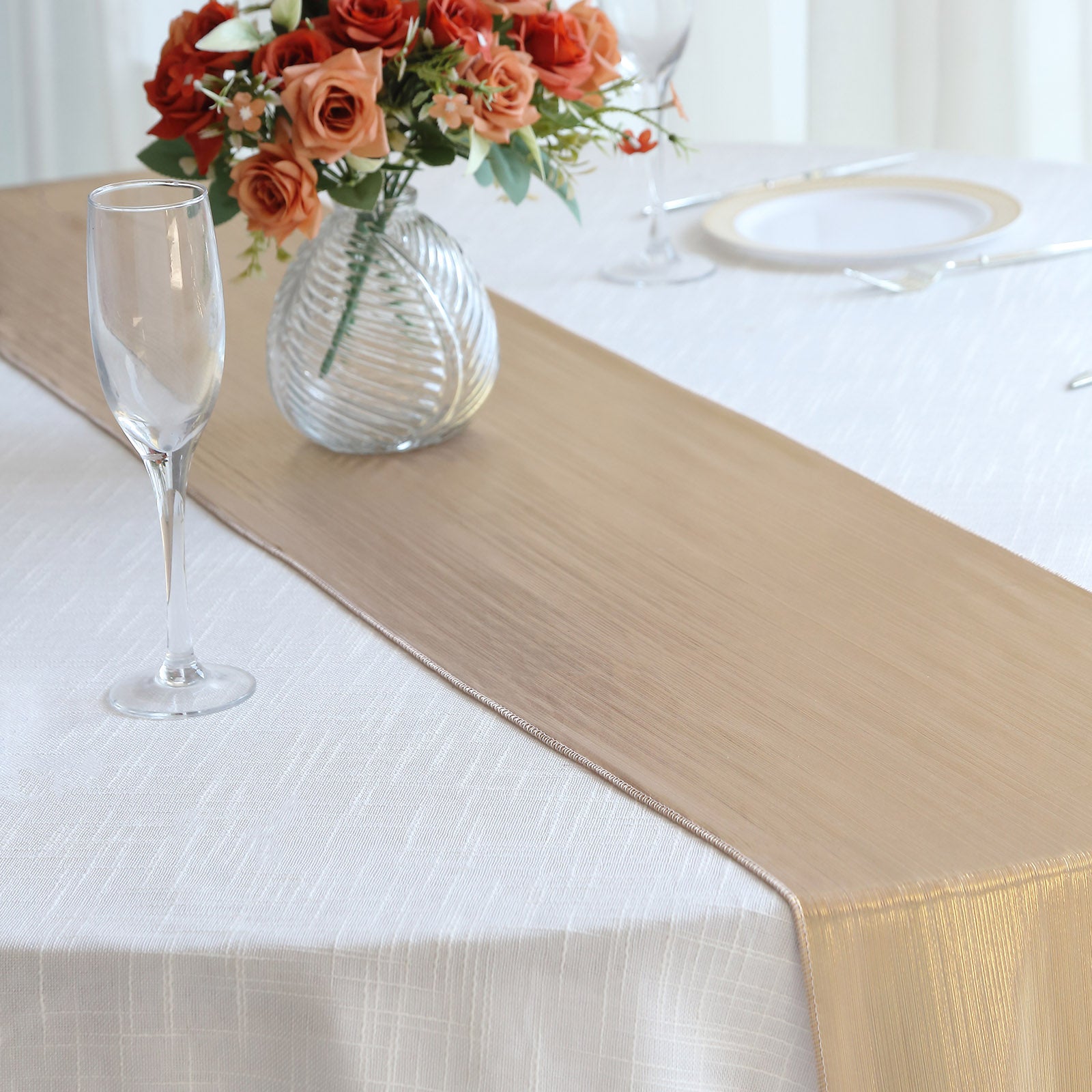 Blush shimmer sequin table runner on a white table with floral arrangement.
