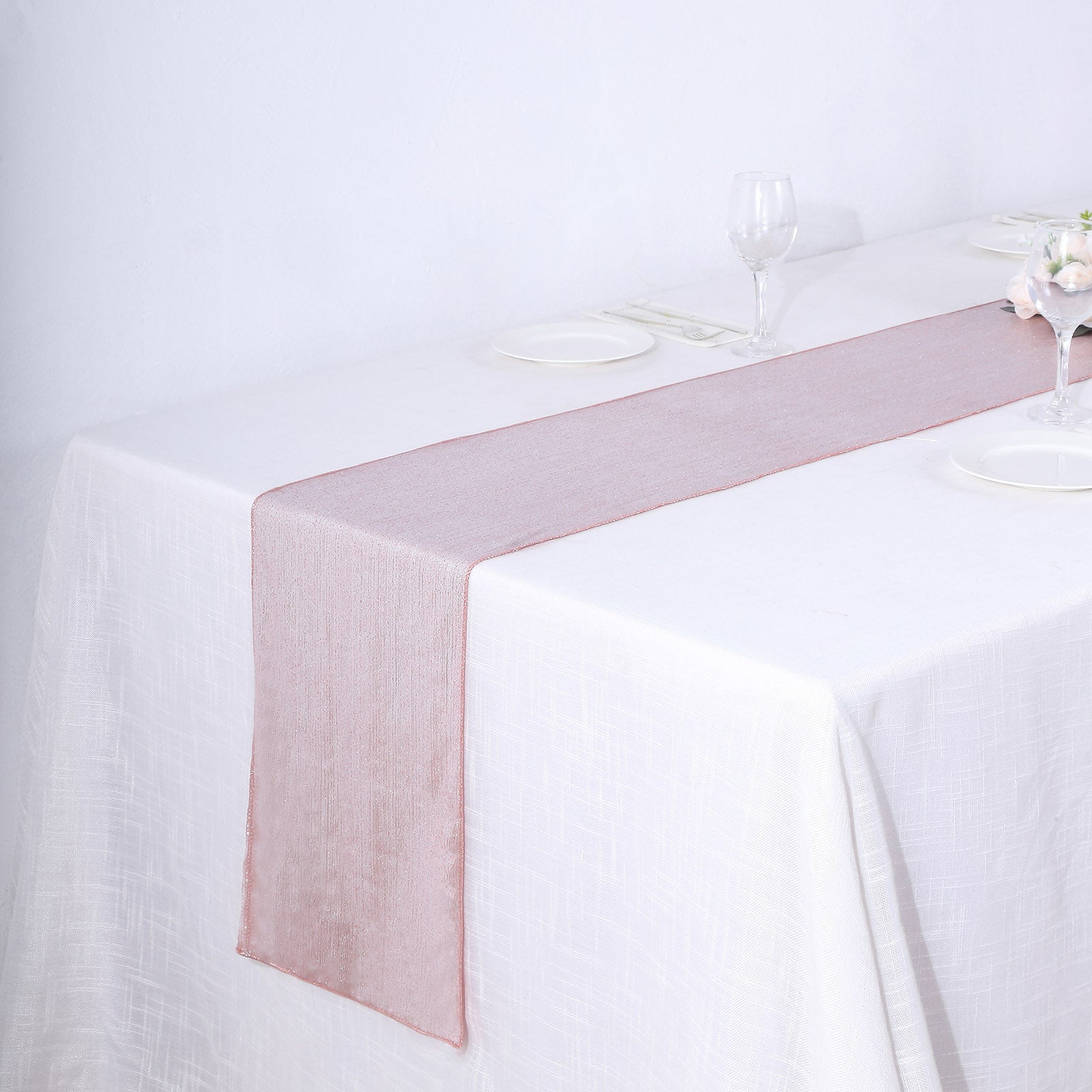 Rose gold shimmer sequin table runner on a white table setting.