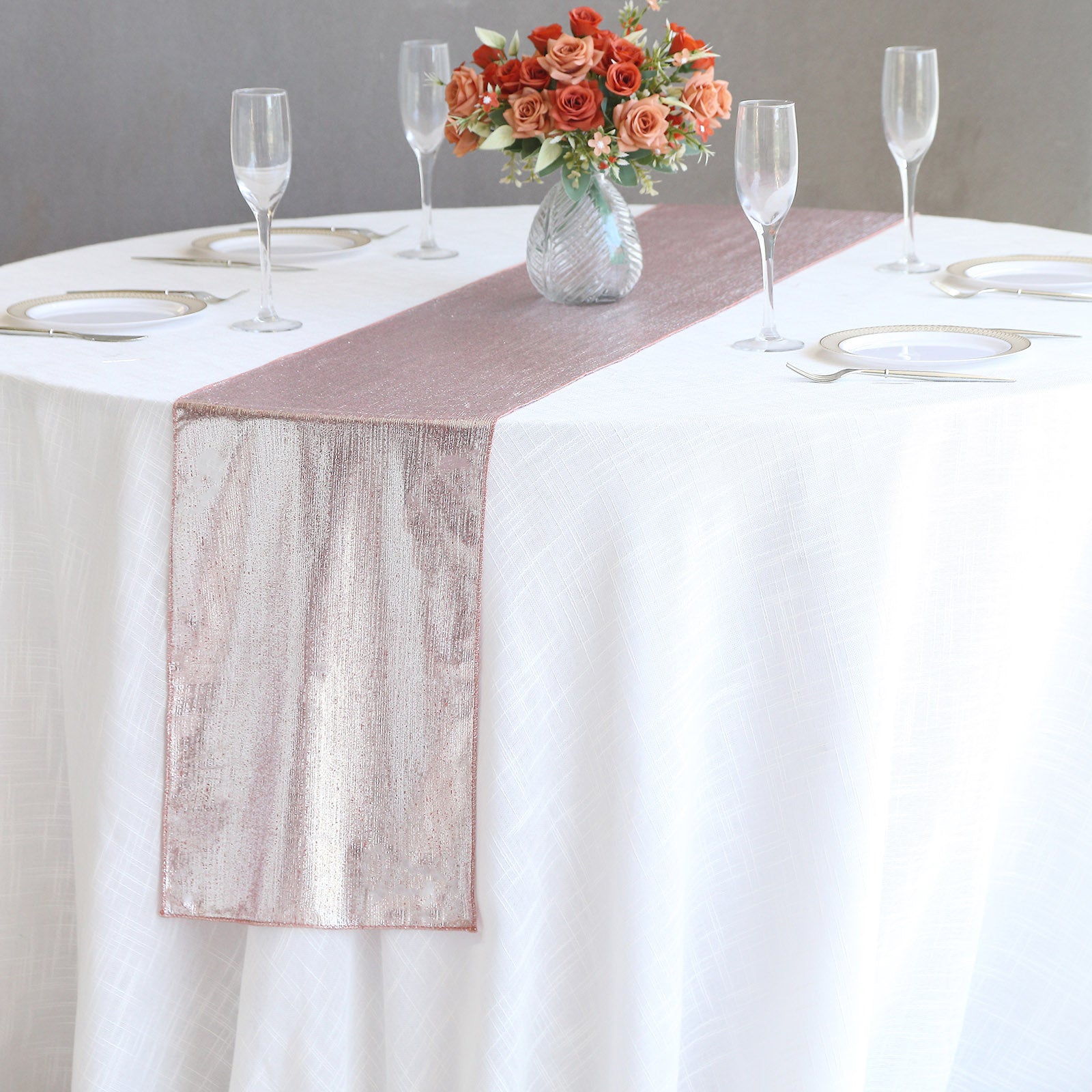 Rose gold shimmer sequin table runner on a white tablecloth