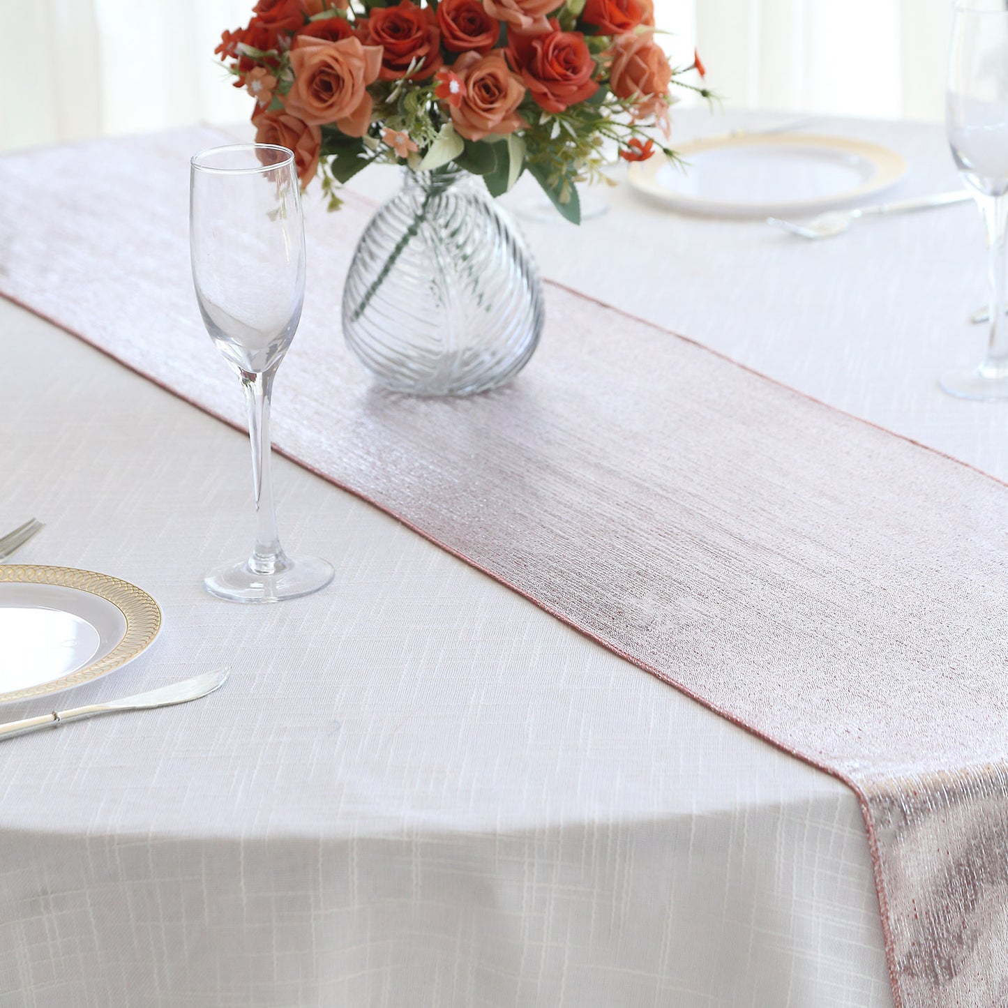 12"x108" rose gold shimmer sequin dots table runner on a white table.